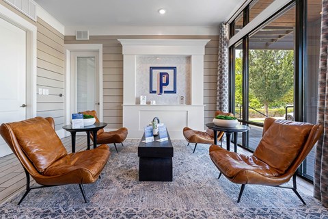 a living room with leather chairs and a fireplace